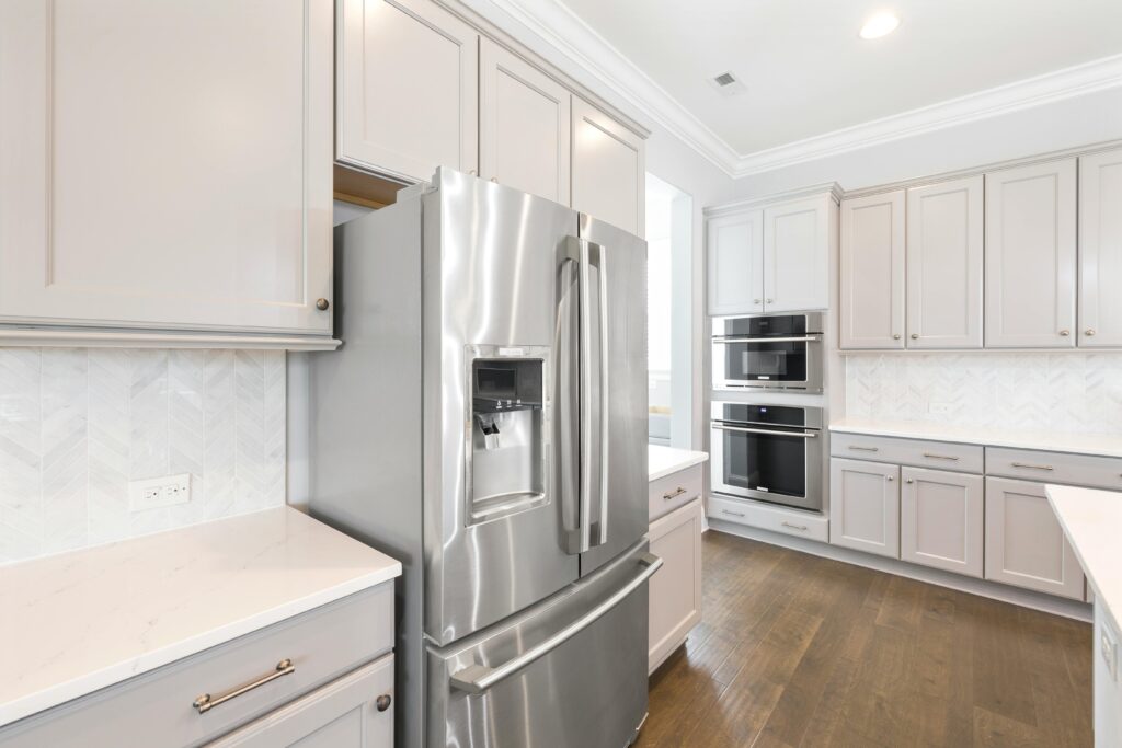 Contemporary kitchen design featuring stainless steel refrigerator and built-in ovens for a sleek look.