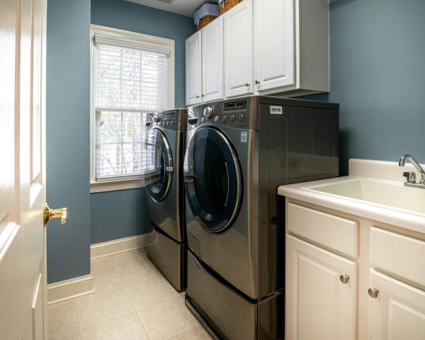A clean, organized laundry room featuring modern appliances and ample storage.