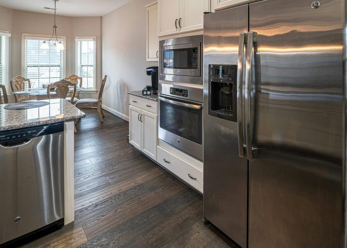 Spacious modern kitchen featuring stainless steel appliances and a dining area.