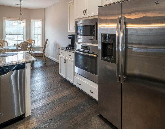 Spacious modern kitchen featuring stainless steel appliances and a dining area.